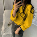 Woman wearing a loose-fit yellow long sleeve top paired with high-waisted jeans, showcasing a casual Korean-style outfit.