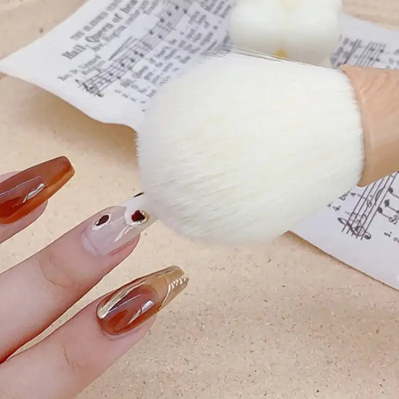 Dust cleaning nail brush in use for manicure with stylish nails and sheet music background, showcasing beauty tools.