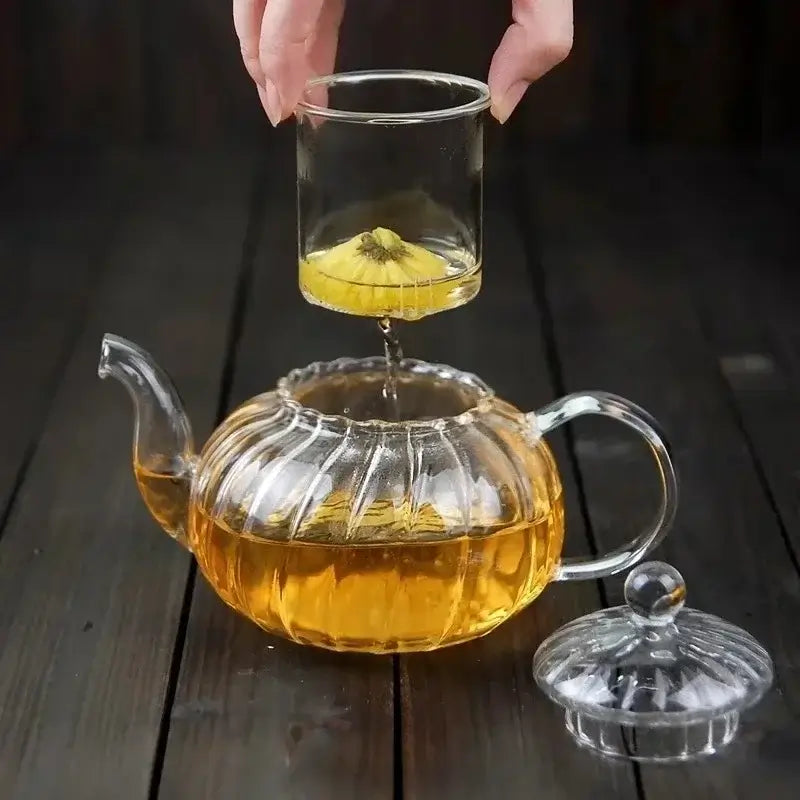 600ml striped pumpkin shape glass teapot with infuser, pouring herbal tea into clear cup.