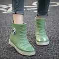 Women wearing green high top rain boots with a glossy finish, perfect for garden and kitchen work.