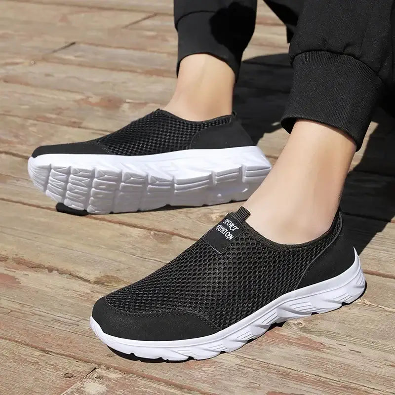 Men's black mesh slip-on sneakers with white sole, designed for summer outdoor activities.