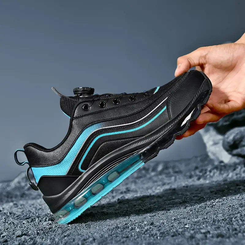 Men's black and turquoise breathable luxury sneakers with lace-up closure and air-cushioned sole on a rocky background.