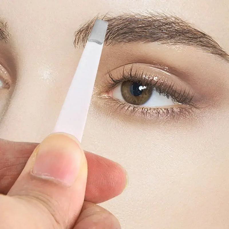 Stainless steel eyebrow tweezer in use for precise eyebrow shaping and grooming.