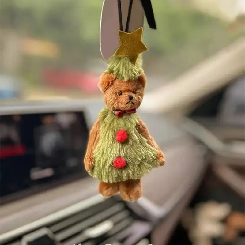 Christmas bear decoration hanging in a car, featuring a festive green outfit and star hat, adding holiday cheer.