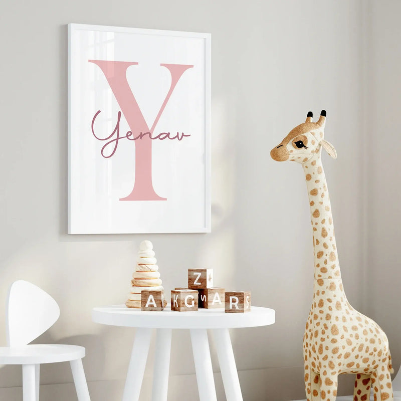 Personalized pink letter 'Y' wall art print in a kids' room with a giraffe and wooden blocks on a table.