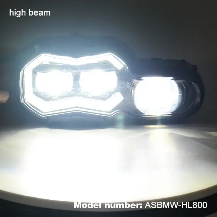 High beam LED projector headlight for BMW F800GS, model ASBMW-HL800, showing bright light output.