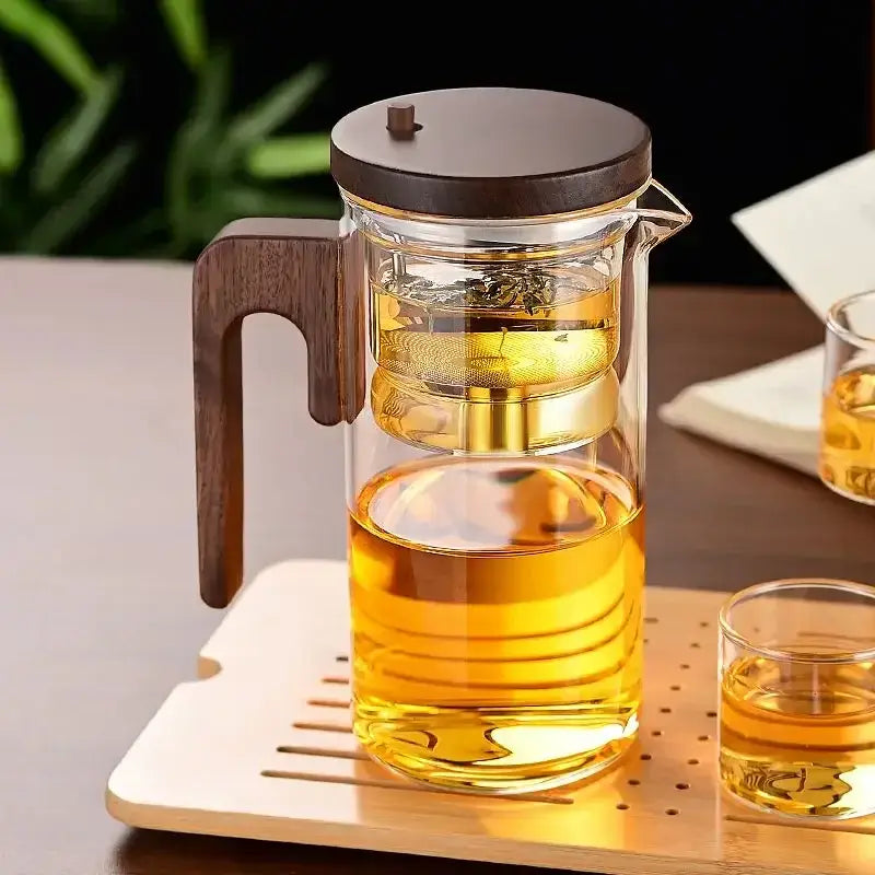 Heat-resistant glass teapot with stainless steel infuser and wooden lid, showcasing brewed tea.