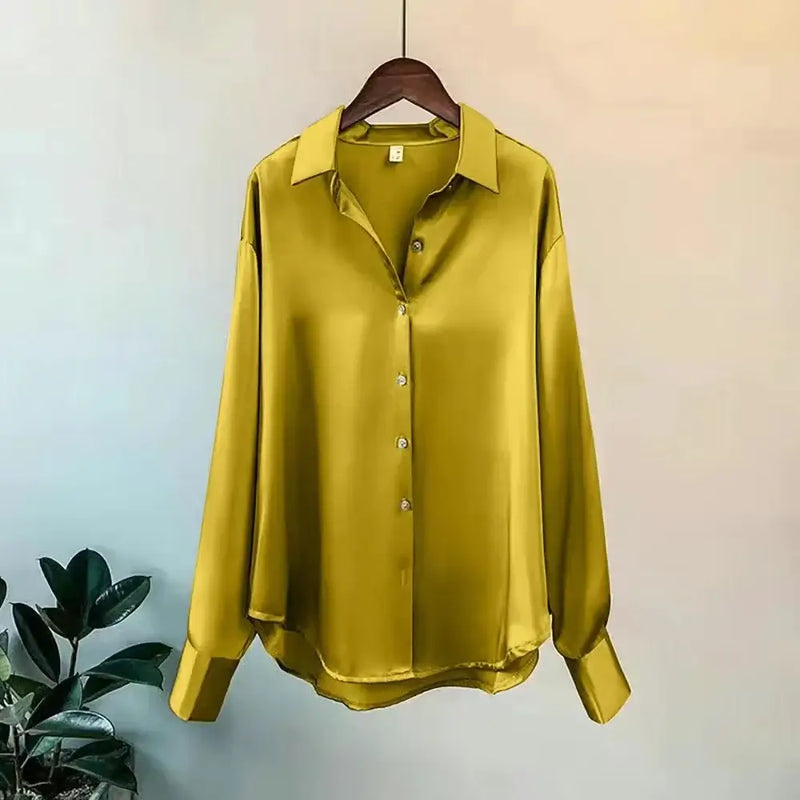 Elegant yellow satin long sleeve shirt with button closure on hanger, perfect for casual wear.