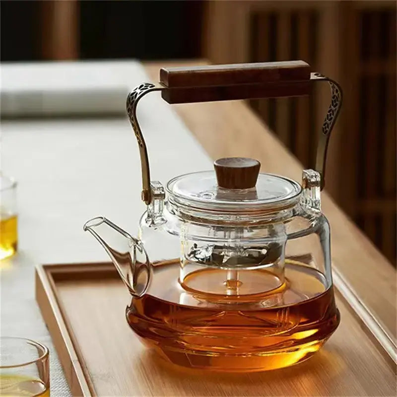 Japanese heat resistant glass tea pot with copper wood handle and tea infuser, elegantly brewed tea.