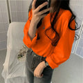 Women wearing a vibrant orange long sleeve T-shirt, styled with high-waisted jeans, showcasing a casual look.